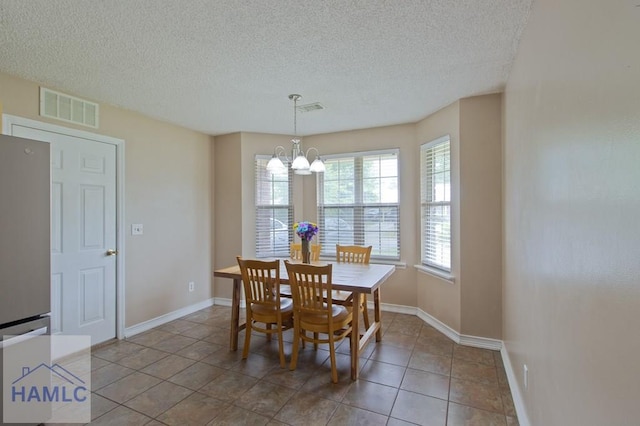 1453 Fritts Ct, Hinesville, GA 31313 - dining room with a chandelier, a textured ceiling, baseboards, and tile patterned flooring