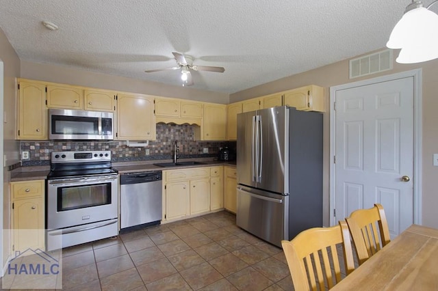 1453 Fritts Ct, Hinesville, GA 31313 - kitchen featuring stainless steel appliances, dark countertops, a sink, backsplash, and a ceiling fan