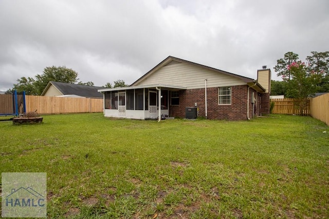 1453 Fritts Ct, Hinesville, GA 31313 - rear view of property featuring a sunroom, a chimney, brick siding, and cooling unit