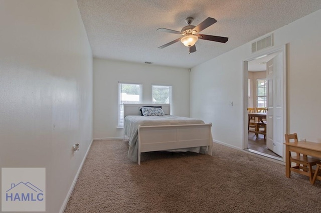 1453 Fritts Ct, Hinesville, GA 31313 - carpeted bedroom featuring a textured ceiling, multiple windows, and ceiling fan