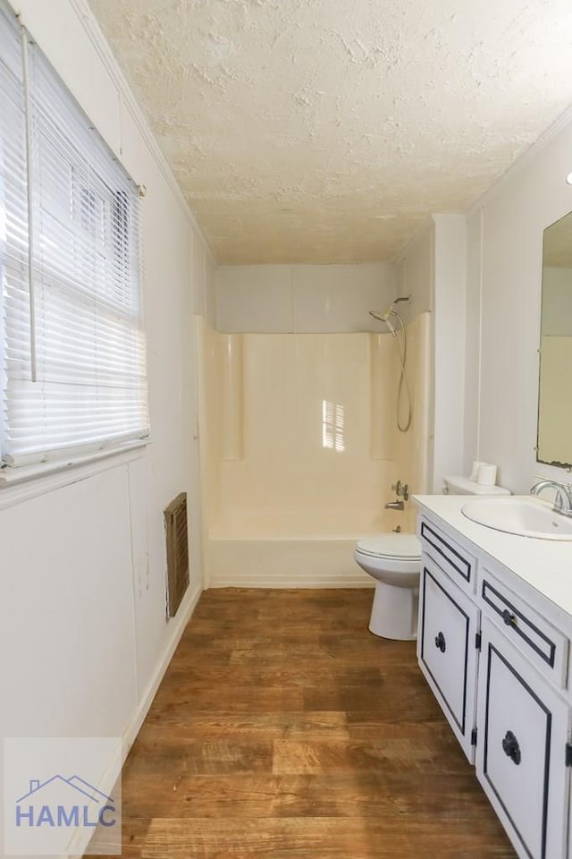 707 Church St, Claxton, GA 30417 - full bathroom featuring shower / bathing tub combination, toilet, wood finished floors, a textured ceiling, and visible vents
