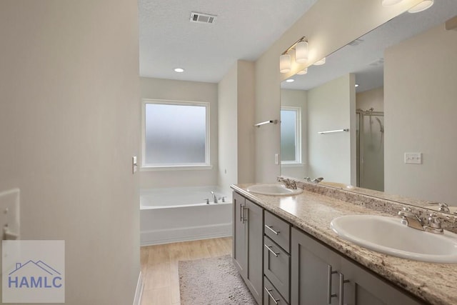 702 Fairview Cir, Hinesville, GA 31313 - full bath featuring double vanity, a bath, a stall shower, and a textured ceiling