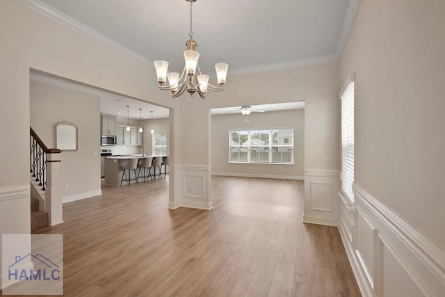 702 Fairview Cir, Hinesville, GA 31313 - unfurnished dining area with a chandelier, stairway, light wood finished floors, crown molding, and a ceiling fan