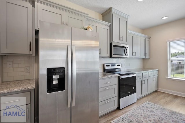 702 Fairview Cir, Hinesville, GA 31313 - kitchen with stainless steel appliances, decorative backsplash, light wood-style flooring, gray cabinets, and recessed lighting
