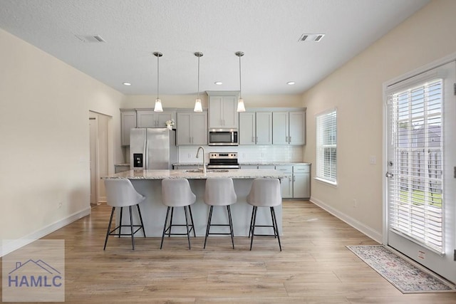 702 Fairview Cir, Hinesville, GA 31313 - kitchen featuring stainless steel appliances, a kitchen island with sink, plenty of natural light, a kitchen bar, and recessed lighting
