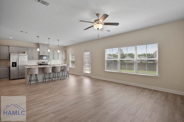 702 Fairview Cir, Hinesville, GA 31313 - living room with a textured ceiling, light wood-style floors, a ceiling fan, and recessed lighting