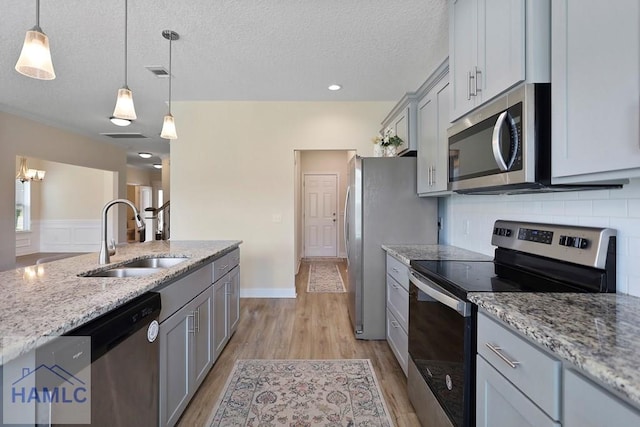 702 Fairview Cir, Hinesville, GA 31313 - kitchen featuring stainless steel appliances, gray cabinetry, a textured ceiling, backsplash, and light wood finished floors