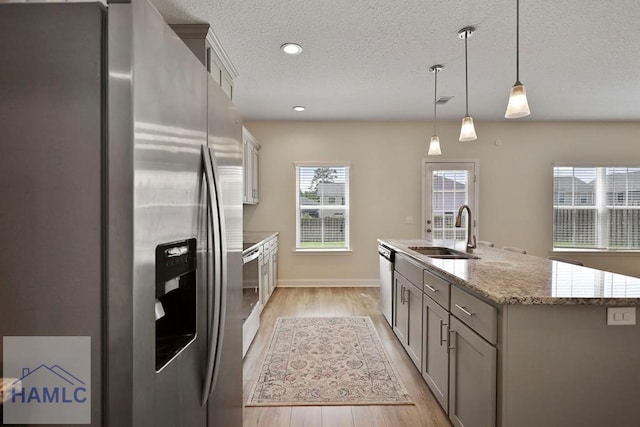 702 Fairview Cir, Hinesville, GA 31313 - kitchen featuring appliances with stainless steel finishes, gray cabinets, light wood finished floors, an island with sink, and a textured ceiling