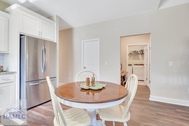 dining room featuring light wood-type flooring and separate washer and dryer