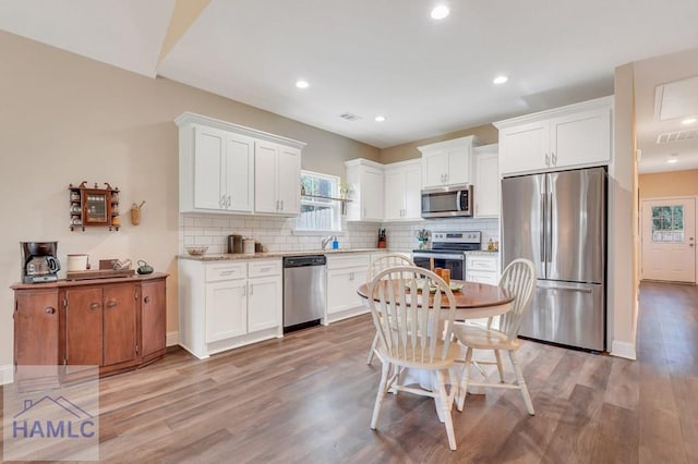 kitchen featuring white cabinets, appliances with stainless steel finishes, and light wood-type flooring