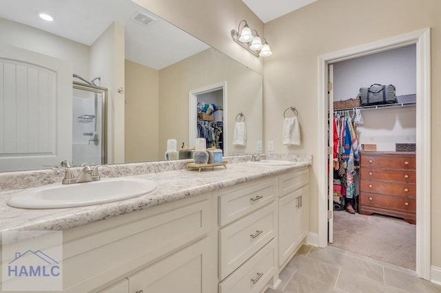 bathroom with tile patterned floors, vanity, and an enclosed shower