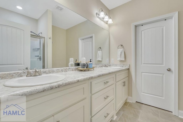 bathroom featuring tile patterned floors, vanity, and a shower with shower door