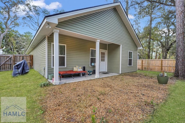 rear view of property with a patio area and a lawn