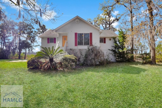 view of front of property featuring a shingled roof and a front yard