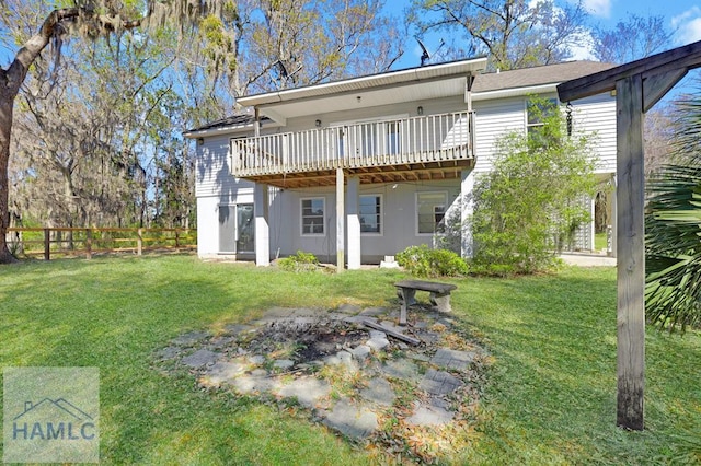 rear view of house featuring fence, a yard, and a wooden deck