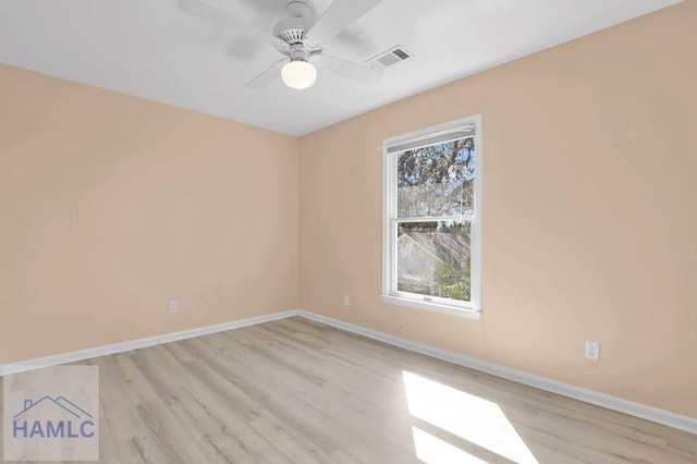 empty room with baseboards, visible vents, wood finished floors, and ceiling fan