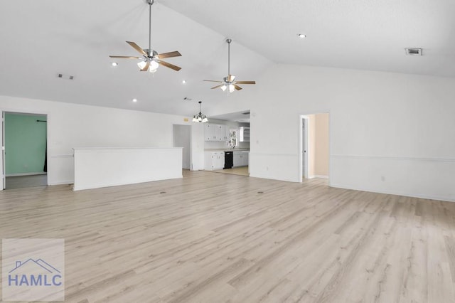 unfurnished living room with light wood-type flooring, high vaulted ceiling, visible vents, and ceiling fan with notable chandelier