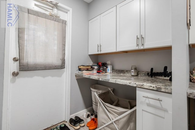 interior space with white cabinets and light stone counters