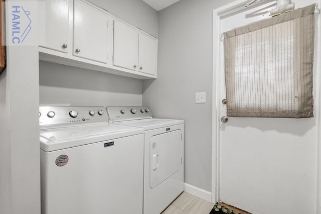 laundry room featuring cabinets, washer and dryer, and light wood-type flooring