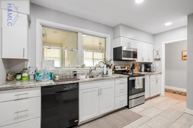 kitchen with light stone countertops, white cabinetry, sink, and appliances with stainless steel finishes