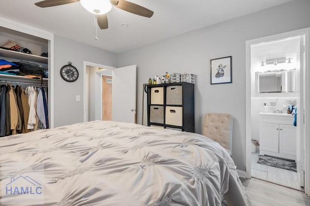 bedroom featuring ensuite bathroom, a closet, ceiling fan, and light wood-type flooring