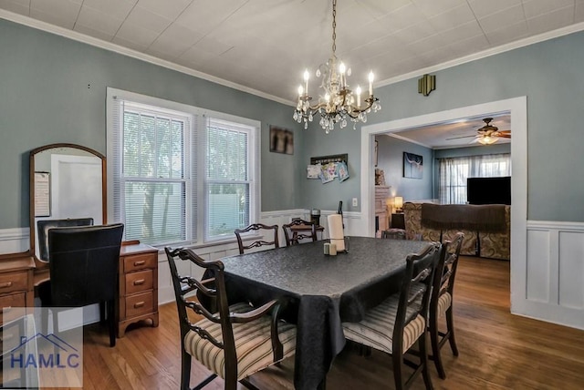 dining room with a wainscoted wall, ornamental molding, a ceiling fan, and wood finished floors