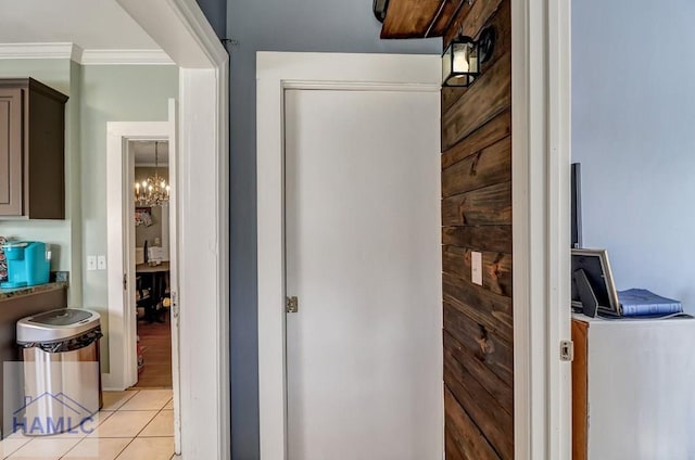 hallway with light tile patterned floors and ornamental molding