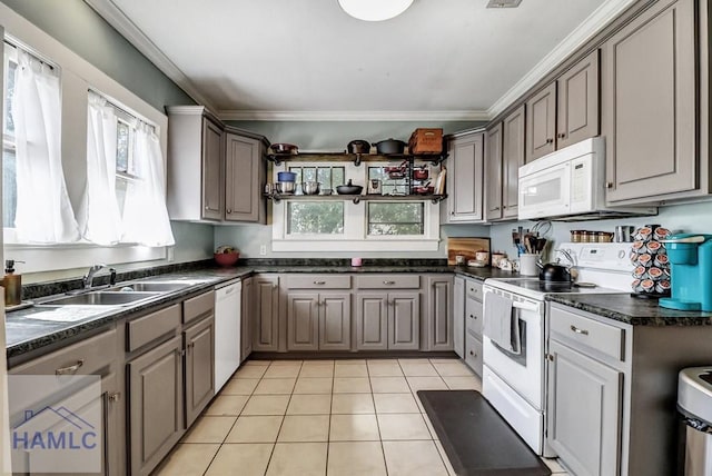 kitchen with dark countertops, crown molding, light tile patterned flooring, white appliances, and a sink