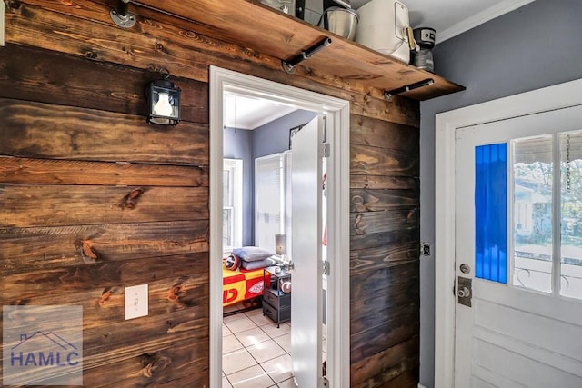 doorway with crown molding and tile patterned flooring