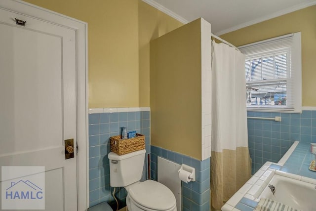 full bath with a wainscoted wall, toilet, tile walls, and crown molding