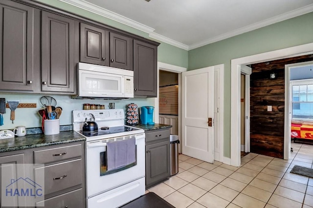 kitchen with light tile patterned flooring, white appliances, crown molding, and baseboards