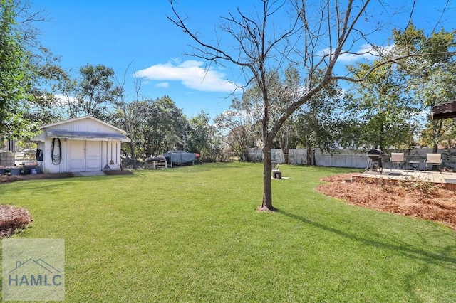 view of yard with an outbuilding, a storage unit, and a fenced backyard