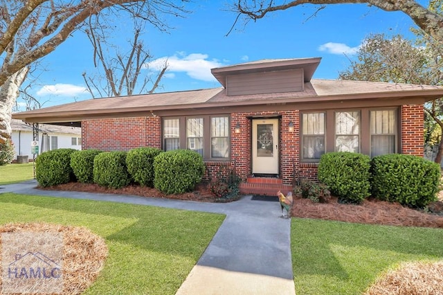 view of front of house with a front lawn and brick siding