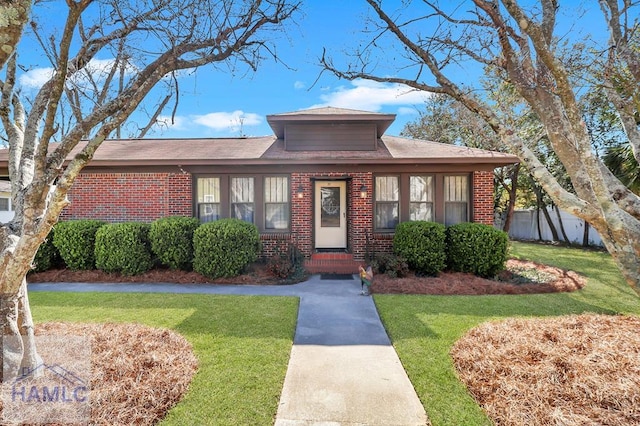 view of front of house with brick siding and a front yard