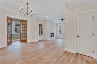 49 Salt Marsh Dr, Midway, GA 31320 - unfurnished living room with a chandelier, ornamental molding, and wood finished floors