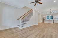 49 Salt Marsh Dr, Midway, GA 31320 - unfurnished living room with stairs, wood finished floors, a ceiling fan, a chandelier, and recessed lighting