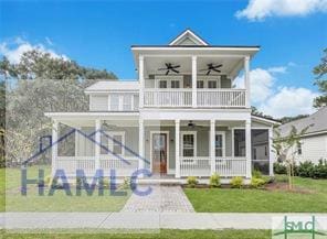49 Salt Marsh Dr, Midway, GA 31320 - view of front of home featuring ceiling fan, covered porch, a balcony, and a front yard