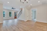 49 Salt Marsh Dr, Midway, GA 31320 - unfurnished living room with stairs, recessed lighting, a chandelier, and wood finished floors