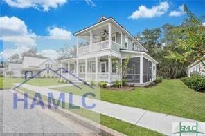 49 Salt Marsh Dr, Midway, GA 31320 - view of front of house featuring a balcony, a ceiling fan, a front yard, and a sunroom
