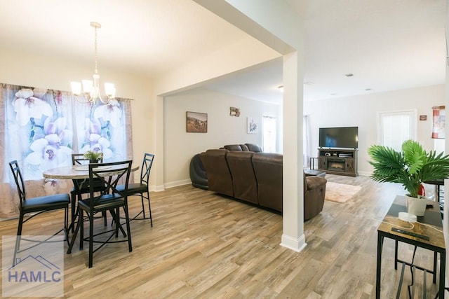 dining area with light hardwood / wood-style flooring and a notable chandelier