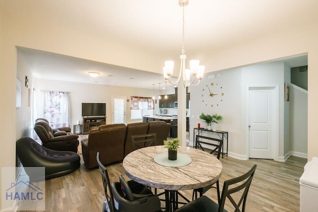 dining area featuring light hardwood / wood-style flooring and a chandelier