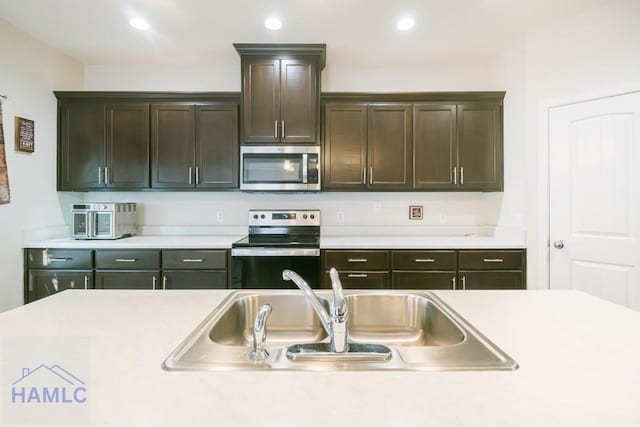 kitchen featuring dark brown cabinetry, stainless steel appliances, and sink