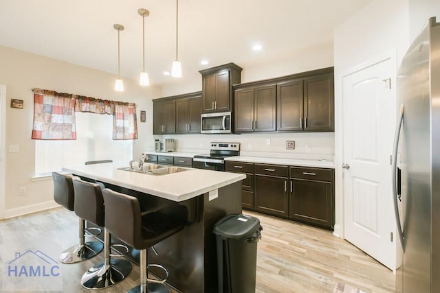 kitchen with hanging light fixtures, dark brown cabinetry, sink, and stainless steel appliances