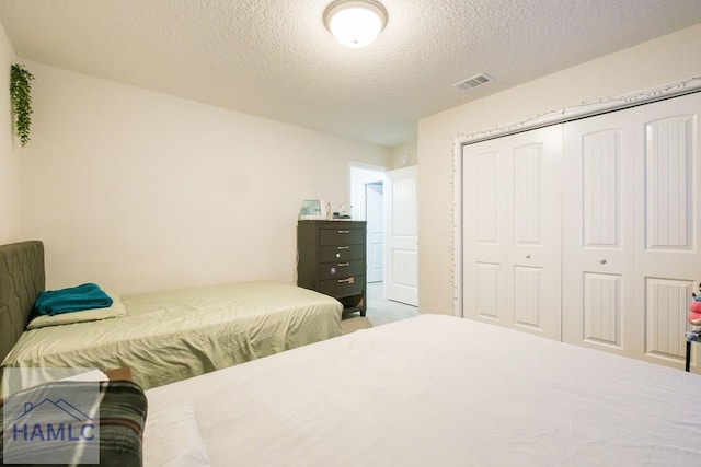 bedroom featuring a textured ceiling and a closet