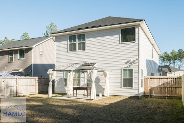 back of property featuring a gazebo, a patio area, and a lawn