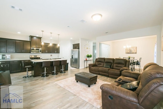 living room with sink and light hardwood / wood-style flooring