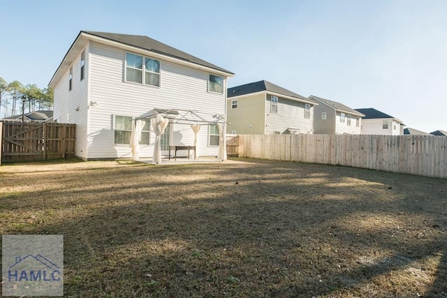 back of property with a lawn, a patio area, and a pergola