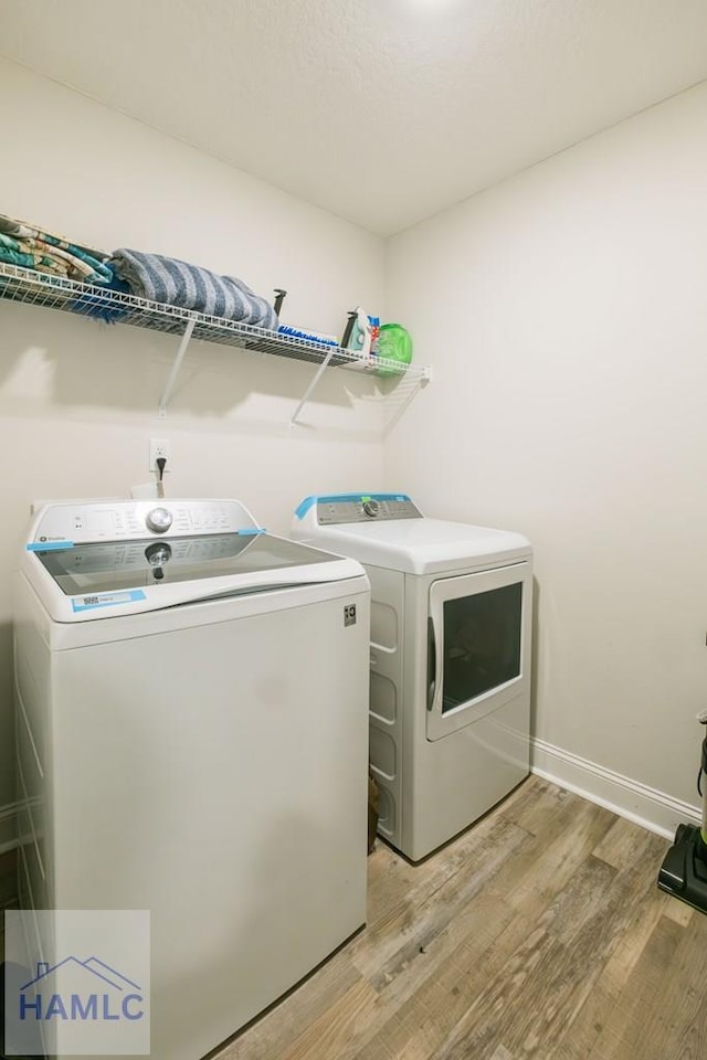 washroom featuring light hardwood / wood-style flooring and washing machine and clothes dryer