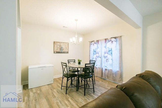 dining room featuring a notable chandelier and light hardwood / wood-style floors