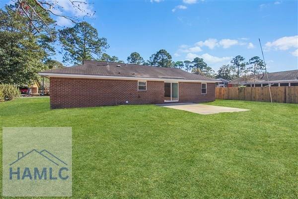 back of property featuring a patio area and a lawn